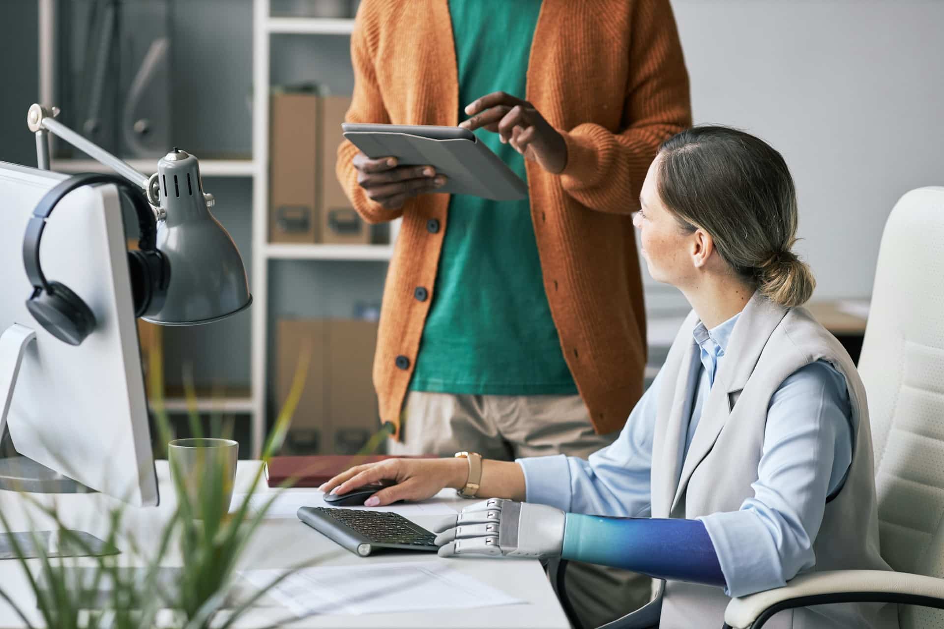 Gruppo di persone con diverse abilità che utilizza dispositivi digitali in modo inclusivo